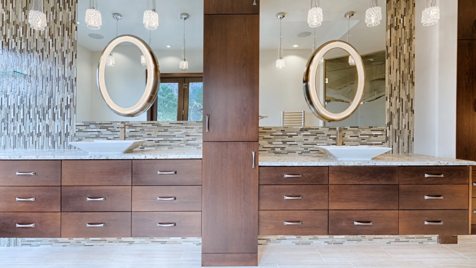 Twin bath vanities in stained wood with oval mirrors
